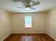 Bright bedroom featuring a ceiling fan, hardwood floors, a large window with natural light and neutral paint at 3340 Zingara Rd, Conyers, GA 30012