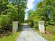 Gated driveway entrance flanked by mature trees, offering a sense of privacy and seclusion at 3340 Zingara Rd, Conyers, GA 30012