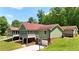 Charming exterior view of a two-story home featuring a brick foundation, green siding, and multi-pane windows at 3340 Zingara Rd, Conyers, GA 30012