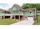 Exterior view of a two-story home with a connected sunroom and basement garage at 3340 Zingara Rd, Conyers, GA 30012