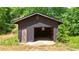 Exterior shot of a small, brown single-car garage shed with a hinged door at 3340 Zingara Rd, Conyers, GA 30012