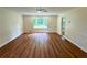 Large living room featuring a beautiful hardwood floor, a ceiling fan, and wainscoting along the walls at 3340 Zingara Rd, Conyers, GA 30012