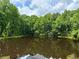 Reflective pond surrounded by lush green trees under a partly cloudy sky, creating a serene outdoor scene at 3340 Zingara Rd, Conyers, GA 30012