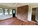 Bright sunroom with hardwood floors, multiple windows offering natural light and a view of trees, and a brick accent wall at 3340 Zingara Rd, Conyers, GA 30012