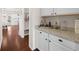 Convenient butler's pantry with granite countertop, white cabinets and easy access to the kitchen and backyard at 496 Spring View Dr, Woodstock, GA 30188