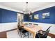 Elegant dining room features blue walls, decorative trim, and a stylish light fixture above the wooden table at 496 Spring View Dr, Woodstock, GA 30188