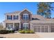 Charming two-story home with a stone facade, three-car garage, and well-manicured lawn at 496 Spring View Dr, Woodstock, GA 30188