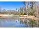 Scenic pond with a bridge, surrounded by trees, reflecting a calm blue sky at 496 Spring View Dr, Woodstock, GA 30188