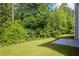 Spacious backyard with a well-kept lawn, a patio, and bordered by thick greenery offering privacy and shade at 6895 Smoke Ridge Dr, Atlanta, GA 30349