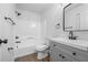 Well-lit bathroom with a shower and tub combination, a gray vanity with a sink and a modern framed mirror at 6895 Smoke Ridge Dr, Atlanta, GA 30349