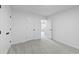 A white-walled bedroom with a neutral carpet is brightened by an adjacent room seen through the doorway at 6895 Smoke Ridge Dr, Atlanta, GA 30349