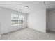 Bright, carpeted bedroom featuring a large window and neutral decor at 6895 Smoke Ridge Dr, Atlanta, GA 30349