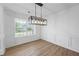 Formal dining room featuring hardwood floors, wainscoting, and a modern light fixture at 6895 Smoke Ridge Dr, Atlanta, GA 30349