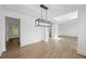 Open-concept dining room adjacent to other living areas featuring hardwood floors, wainscoting, and a modern light fixture at 6895 Smoke Ridge Dr, Atlanta, GA 30349