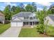 Charming two-story home featuring a well-manicured lawn, attached two-car garage, and traditional architectural details at 6895 Smoke Ridge Dr, Atlanta, GA 30349