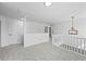 Carpeted upstairs hallway with white railing and modern chandelier at 6895 Smoke Ridge Dr, Atlanta, GA 30349