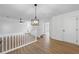 Open-concept living room showcasing wood floors, modern light fixture, and staircase access at 6895 Smoke Ridge Dr, Atlanta, GA 30349