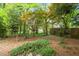A private backyard includes various trees, ground cover, and a small concrete patio at 1000 Grimes Bridge Rd, Roswell, GA 30075