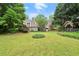 Expansive backyard with lush lawn, mature trees, brick house, and an outdoor structure at 1000 Grimes Bridge Rd, Roswell, GA 30075