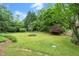Manicured backyard space with beautiful green grass, plantings, and stone pathway at 1000 Grimes Bridge Rd, Roswell, GA 30075