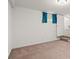 Unfinished basement area featuring neutral carpet, a window with blue curtains, and a stairway at 1000 Grimes Bridge Rd, Roswell, GA 30075