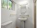 Bright bathroom featuring pedestal sink with gold fixtures, mirror, and toilet at 1000 Grimes Bridge Rd, Roswell, GA 30075