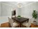 Dining room with modern chandelier, hardwood flooring, wainscoting, and a dark wood table for six at 1000 Grimes Bridge Rd, Roswell, GA 30075