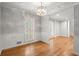 Elegant dining room featuring hardwood flooring, modern lighting fixture, wainscoting, and plantation shutters at 1000 Grimes Bridge Rd, Roswell, GA 30075