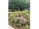 A vibrant azalea bush in full bloom adds color and curb appeal to the well-maintained landscape at 1000 Grimes Bridge Rd, Roswell, GA 30075