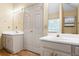 Bathroom featuring double sinks with cabinets, a large mirror, and ample lighting at 15 Ashton Pl, Covington, GA 30016