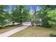 Beautiful home with mature trees, well-maintained lawn, and a long driveway leading to the two-car garage at 15 Ashton Pl, Covington, GA 30016