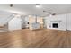 Spacious living room with wood floors, fireplace, staircase and open kitchen offering a welcoming and modern feel at 15 Ashton Pl, Covington, GA 30016