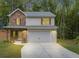 Charming two-story home featuring a stone facade, light siding, and an attached two-car garage in a lush, wooded setting at 191 Davis Ct, Hiram, GA 30141