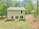Exterior back of home with cream siding and a large yard surrounded by mature trees at 191 Davis Ct, Hiram, GA 30141