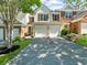 Attractive townhome with two-car garage, lawn, and tidy landscaping, with a tree in front at 220 Finchley Dr, Roswell, GA 30076