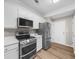 Modern kitchen featuring stainless steel appliances, sleek countertops, and ample cabinet space at 220 Finchley Dr, Roswell, GA 30076
