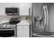 Close-up of modern kitchen appliances including refrigerator, stove, and microwave at 220 Finchley Dr, Roswell, GA 30076
