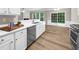 Bright kitchen with stainless steel appliances, white cabinets, and wood floors at 220 Finchley Dr, Roswell, GA 30076
