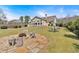 Spacious backyard offers outdoor living space with stone fire pit, table with umbrella, and wooden privacy fence at 2767 Camp Mitchell Rd, Loganville, GA 30052