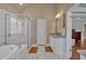 Spacious bathroom features soaking tub, glass shower, double vanity and marble tile at 2767 Camp Mitchell Rd, Loganville, GA 30052