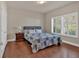Bedroom features a quilt bedspread, wood floors and a window with plantation shutters at 2767 Camp Mitchell Rd, Loganville, GA 30052