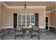Inviting covered patio with stone accents, two chairs, and a small side table perfect for relaxation at 2767 Camp Mitchell Rd, Loganville, GA 30052