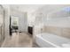Bathroom featuring a soaking tub, walk-in shower, and view to the main bedroom at 5465 Mirror Lake Dr, Cumming, GA 30028