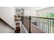 Upstairs hallway with wooden railing and views to the backyard and downstairs entryway at 5465 Mirror Lake Dr, Cumming, GA 30028
