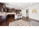 Spacious kitchen with dark wood cabinets, stainless steel appliances, granite countertops, and an island with bar seating at 5465 Mirror Lake Dr, Cumming, GA 30028