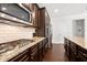 Featuring dark wood cabinets, granite countertops, and stainless steel appliances, this kitchen is ready for entertaining at 5465 Mirror Lake Dr, Cumming, GA 30028