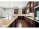 This modern kitchen features dark wood cabinets, granite countertops, and stainless steel appliances at 5465 Mirror Lake Dr, Cumming, GA 30028