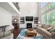 Bright living room featuring a fireplace, built-in shelving, and large windows with backyard views at 5465 Mirror Lake Dr, Cumming, GA 30028