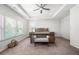 Spacious main bedroom featuring tray ceilings, a ceiling fan, and large windows at 5465 Mirror Lake Dr, Cumming, GA 30028