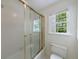 Bathroom with a window and a tub with a gold framed shower door at 1730 Point Pleasant Se, Smyrna, GA 30080